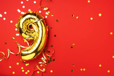 Altın folyo balon numarası ve 99. rakam. Doğum günü tebrik kartı. Yıldönümü kutlaması. Pankart. Uzayı kopyala Şık altın rakamlı, parlak parıltılı, kırmızı arkaplan. Sayısal rakam