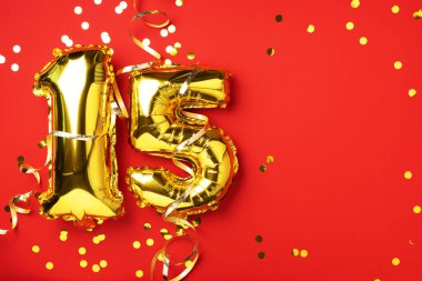 Altın folyo balon numarası, rakam 15. Doğum günü tebrik kartı, 15. yazı. Yıldönümü kutlaması. Pankart. Şık altın rakamlı, parlak parıltılı, kırmızı arkaplan. Sayısal rakam.