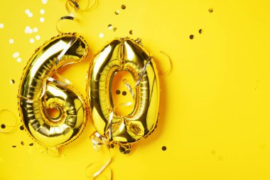 Altın folyo balon numarası, altmış basamaklı. Doğum günü tebrik kartı, yazıt 60. Yıldönümü kutlaması. Pankart. Altın rakamlı, sarı arkaplan. Sayısal rakam, parlak parlak parıltı