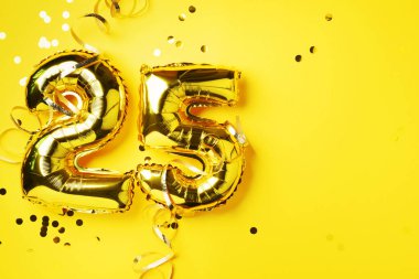 Altın folyo balon numarası, rakam 25. Üzerinde 25 yazan doğum günü tebrik kartı. Yıldönümü kutlaması. Pankart. Altın rakamlı, sarı arkaplan. Sayısal rakam, parlak parlak parıltı.