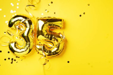 Altın folyo balon numarası, 35 haneli rakam. Doğum günü tebrik kartı, yazıt 35. Yıldönümü kutlaması. Pankart. Altın rakamlı, sarı arkaplan. Sayısal rakam, parlak parlak parıltı.