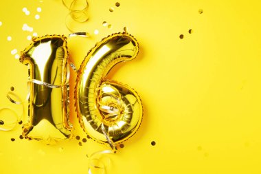 Altın folyo balon numarası, sayı 16. Doğum günü tebrik kartı, 16. yazı. Yıldönümü kutlaması. Pankart. Şık altın rakamlı, parlak parıltılı, sarı arkaplan. Sayısal rakam.