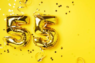 Altın folyo balon numarası, doksan beş. Doğum günü tebrik kartı, yazıt 95. Yıldönümü kutlaması. Pankart. Altın rakamlı, sarı arkaplan. Sayısal rakam, parlak parlak parıltı.