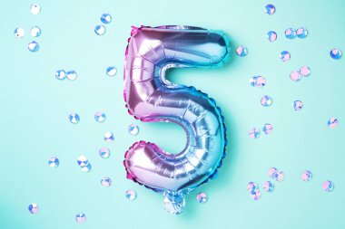 Yaratıcı düzen. Gökkuşağı folyo balon numarası ve rakam beş beş beş. Doğum günü tebrik kartı. Yıldönümü konsepti. Üst Manzara. Uzayı kopyala Mavi arkaplan üzerinde renkli sayılar. Sayısal rakam