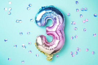 Yaratıcı düzen. Gökkuşağı folyo balon numarası ve rakam üç üç. Doğum günü tebrik kartı. Yıldönümü konsepti. Üst Manzara. Uzayı kopyala Mavi arkaplan üzerinde renkli sayılar. Sayısal rakam