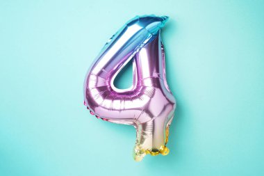 Yaratıcı düzen. Gökkuşağı folyo balon numarası ve sayı dört dört. Doğum günü tebrik kartı. Yıldönümü konsepti. Üst Manzara. Uzayı kopyala Mavi arkaplan üzerinde renkli sayılar. Sayısal rakam