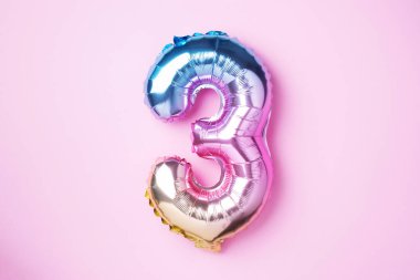 Yaratıcı düzen. Gökkuşağı folyo balon numarası ve rakam üç üç. Doğum günü tebrik kartı. Yıldönümü konsepti. Üst Manzara. Uzayı kopyala Pembe arka planda şık renkli sayılar. Sayısal rakam
