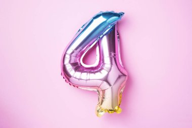 Yaratıcı düzen. Gökkuşağı folyo balon numarası ve sayı dört dört. Doğum günü tebrik kartı. Yıldönümü konsepti. Üst Manzara. Uzayı kopyala Pembe arka planda şık renkli sayılar. Sayısal rakam