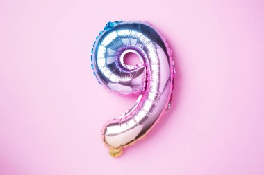 Yaratıcı düzen. Gökkuşağı folyo balon numarası ve rakam dokuz dokuz dokuz. Doğum günü tebrik kartı. Yıldönümü konsepti. Üst Manzara. Uzayı kopyala Pembe arka planda şık renkli sayılar. Sayısal rakam