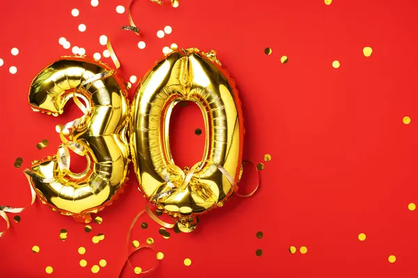Altın folyo balon numarası, sayı 30. Doğum günü tebrik kartında 30 yazılıydı. Yıldönümü kutlaması. Pankart. Altın rakamlı, kırmızı arkaplan. Sayısal rakam, parlak parlak parıltı