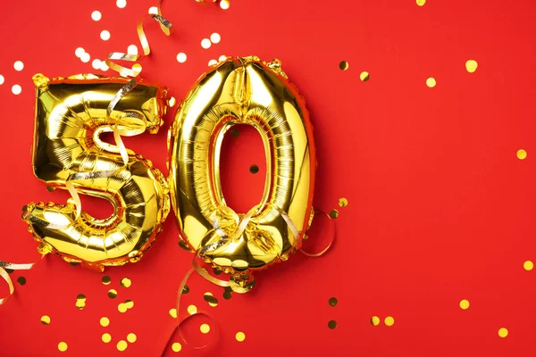 Altın folyo balon numarası, 50 haneli. Doğum günü tebrik kartında 50 yazılıydı. Yıldönümü kutlaması. Pankart. Altın rakamlı, kırmızı arkaplan. Sayısal rakam, parlak parlak parıltı