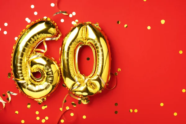 Altın folyo balon numarası, altmış basamaklı. Altmış yazılı doğum günü tebrik kartı. Yıldönümü kutlaması. Pankart. Altın rakamlı, kırmızı arkaplan. Sayısal rakam, parlak parlak parıltı