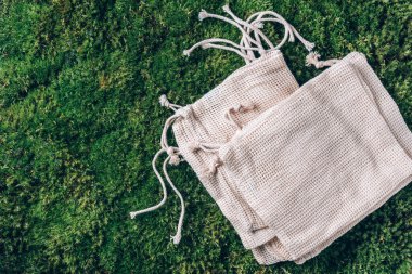 Yeşil çimenli örgü ve pamuk torbaları, yosun arkaplan. Üst Manzara. Sürdürülebilir ekoloji yaşam tarzı. Sıfır atık. Plastik yok. Plastiksiz, organik konsept. Çevre dostu ağ tüccarı.