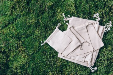 Yeşil çimenli örgü ve pamuk torbaları, yosun arkaplan. Üst Manzara. Sürdürülebilir ekoloji yaşam tarzı. Sıfır atık. Plastik yok. Plastiksiz, organik konsept. Çevre dostu ağ tüccarı.