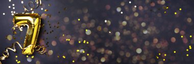 Altın folyo balon numarası ve 7 haneli rakam. Doğum günü tebrik kartı. Yıldönümü kutlaması. Pankart. Uzayı kopyala Şık altın rakamlı, açık renkli, parlak, siyah arkaplan. Sayısal rakam