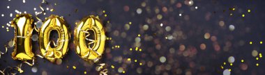 Altın folyo balon numarası, 100 haneli rakam. Doğum günü tebrik kartında 100 yazılıydı. Yıldönümü kutlaması. Pankart. Altın rakamlı, siyah arkaplan. Sayısal rakam, ışık bokeh, parıltı.
