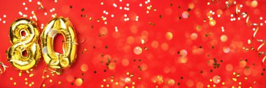 Altın folyo balon numarası, 80 haneli. 80 yazılı doğum günü tebrik kartı var. Yıldönümü kutlaması. Pankart. Altın rakamlı, kırmızı arkaplan. Sayısal rakam, ışık bokeh, parıltı