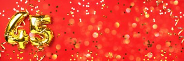 Altın folyo balon numarası, 45 haneli rakam. 45 yazılı doğum günü tebrik kartı var. Yıldönümü kutlaması. Pankart. Altın rakamlı, kırmızı arkaplan. Sayısal rakam, ışık bokeh, parıltı.