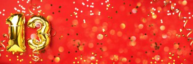 Altın folyo balon numarası, 13 numara. Doğum günü tebrik kartı, 13. yazı. Yıldönümü kutlaması. Pankart. Şık altın rakamlı, parlak, kırmızı arkaplan. Sayısal rakam.