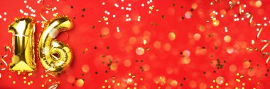 Altın folyo balon numarası, sayı 16. Doğum günü tebrik kartı, 16. yazı. Yıldönümü kutlaması. Pankart. Şık altın rakamlı, parlak, kırmızı arkaplan. Sayısal rakam.
