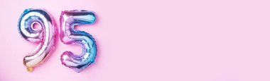 Gökkuşağı folyo balon numarası, doksan beş. Doğum günü tebrik kartında 95 yazılıydı. Yıldönümü konsepti. Üst Manzara. Pembe arka planda renkli sayı. Sayısal rakam, kutlama etkinliği.