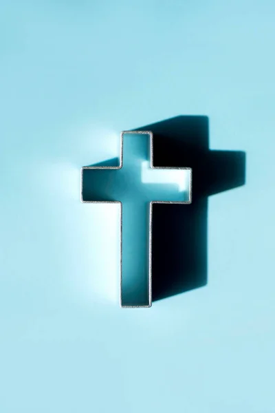 Church worship, salvation concept. Silhouette of christian cross on blue background, soft bokeh lights background. Copy space. Faith symbol in Jesus Christ. Holy cross for Christmas, Easter day.