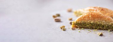 Baklava with pistachios on grey background. Jewish, turkish, arabic traditional national dessert. Macro. Selective focus. Copy space. Eastern sweets, turkish delight.