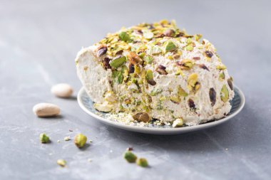 Gri arka planda fıstıklı susam halkası. Üst Manzara. Uzayı kopyala Geleneksel Orta Doğu tatlıları. Yahudi, Türk, Arap ulusal tatlısı. Türk lokumu.