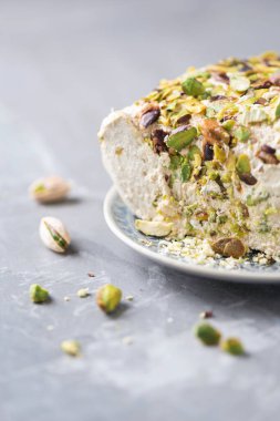 Gri arka planda fıstıklı susam halkası. Üst Manzara. Uzayı kopyala Geleneksel Orta Doğu tatlıları. Yahudi, Türk, Arap ulusal tatlısı. Türk lokumu.