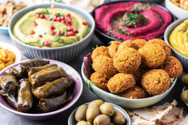 Geleneksel Arap yemekleri. Pide, zeytin, renkli humus, falafel, dolma dolma, babaganush, turşu, sebze, nar, patlıcan. Akdeniz meze partisi fikri.