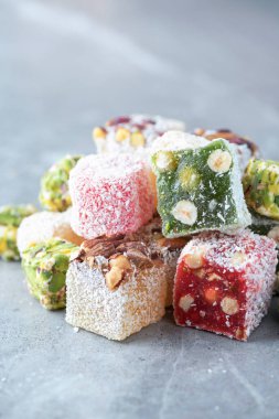 Turkish delight with pistachios on grey background. Copy space. Traditional eastern cuisine. Traditional middle eastern sweets. Jewish, turkish, arabic national dessert. Turkish delight.