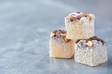 Turkish delight with pistachios on grey background. Copy space. Traditional eastern cuisine. Traditional middle eastern sweets. Jewish, turkish, arabic national dessert. Turkish delight.