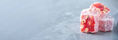 Turkish delight with hazelnuts on grey background. Copy space. Traditional eastern cuisine. Traditional middle eastern sweets. Jewish, turkish, arabic national dessert. Turkish delight.