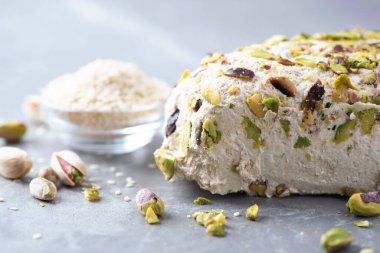 Gri arka planda fıstıklı susam halkası. Üst Manzara. Uzayı kopyala Geleneksel Orta Doğu tatlıları. Yahudi, Türk, Arap ulusal tatlısı. Türk lokumu.