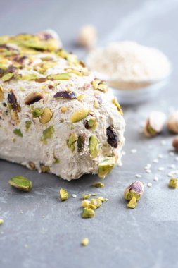 Gri arka planda fıstıklı susam halkası. Üst Manzara. Uzayı kopyala Geleneksel Orta Doğu tatlıları. Yahudi, Türk, Arap ulusal tatlısı. Türk lokumu.