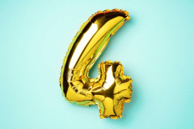 Yaratıcı düzen. Altın folyo balon numarası ve 4 haneli rakam. Doğum günü tebrik kartı. Yıldönümü konsepti. Üst Manzara. Uzayı kopyala Mavi arka planda zarif altın rakamı. Sayısal rakam