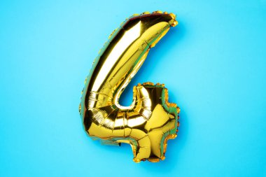 Yaratıcı düzen. Altın folyo balon numarası ve 4 haneli rakam. Doğum günü tebrik kartı. Yıldönümü konsepti. Üst Manzara. Uzayı kopyala Mavi arka planda zarif altın rakamı. Sayısal rakam