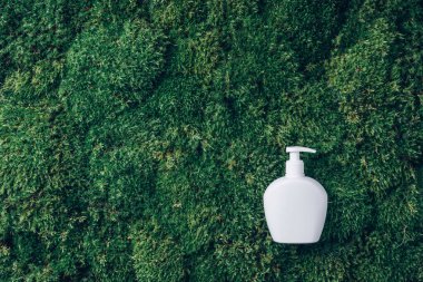 Yeşil yosun arka planında etiketsiz kozmetik şişe. Biyofilik tasarım. Cilt bakımı, organik vücut bakımı, spa konsepti. Vegan çevre dostu kozmetoloji ürünü. Organik Kozmetik