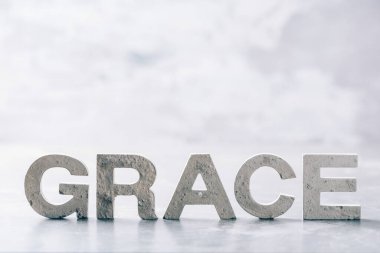 Word GRACE made with cement letters on grey marble background. Copy space. Biblical, spiritual or christian reminder.