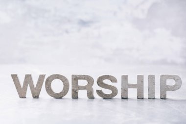 Word Worship made with cement letters on grey marble background. Copy space. Biblical, spiritual or christian reminder. Good friday, Easter day in church. Christian music concert, Sunday service.