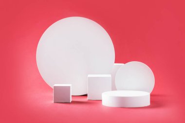 White geometric shapes podium for product display on coral pink background. Monochrome stage, stand for product promotion in minimal style. Copy space for your design. Banner.