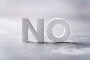 Word NO made with cement letters on grey marble background. Copy space. Business concept.