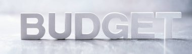 Word BUDGET made with cement letters on grey marble background. Copy space. Business, economy, money, finance planning concept.