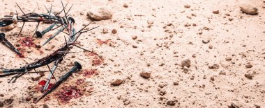 Crown of thorns, bloody nails on sand background. Good Friday, Passion of Jesus Christ. Christian Easter holiday. Top view, copy space. Crucifixion, resurrection of Jesus Christ. Gospel, salvation.