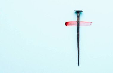 Christian cross made with rusty nails, drops of blood on blue background. Copy space. Good Friday, Easter day. Christian backdrop. Biblical faith, gospel, salvation concept. Jesus Christ Crucifixion.