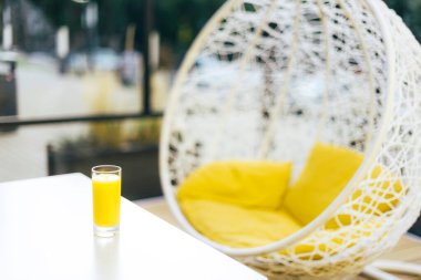 Açık havada minimalist tarzında sarı yastıklı hasır sandalye asmak. 2021 yılının modaya uygun rengini gösteriyor. Aydınlatıcı sarı ve nihai gri. Duotone. Depresyon tedavisi.