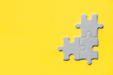 2021 yılının modaya uygun rengini gösteriyor. Aydınlatıcı sarı ve nihai gri. Duotone. Çoklu gri yapboz parçaları sarı arkaplanda tek bir parça olmadan bir araya getirildi.