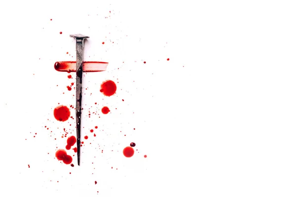 Christian cross made with rusty nails, drops of blood on white background. Copy space. Good Friday, Easter day. Christian backdrop. Biblical faith, gospel, salvation concept. Jesus Christ Crucifixion.