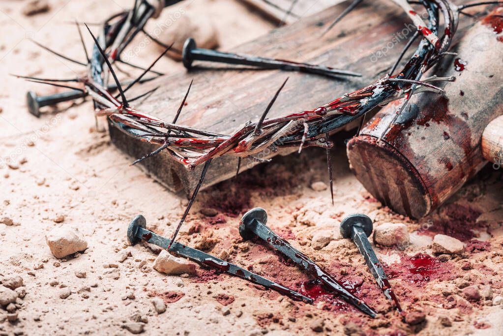 Old wooden cross, hammer, bloody nails and crown of thorns on ground. Banner. Copy space. Good friday. Passion, crucifixion of Jesus Christ. Christian Easter holiday. Gospel, salvation.