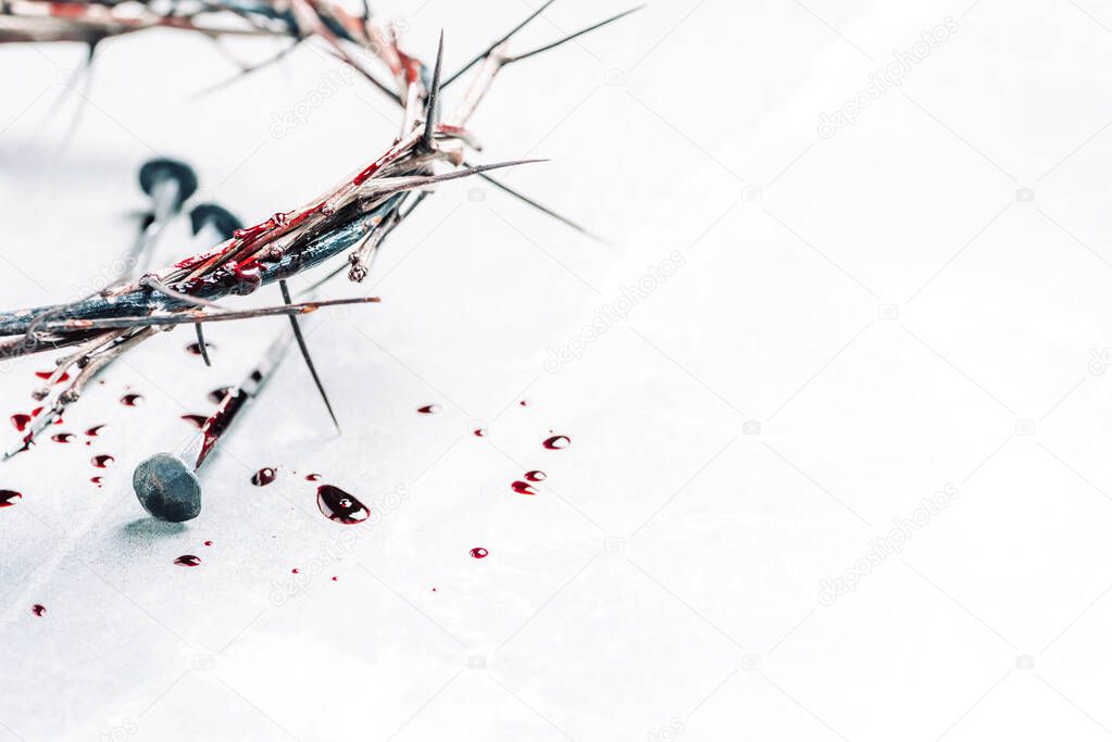 Christian crown of thorns with drops of blood, nails on grey background. Good Friday, Passion of Jesus Christ. Easter holiday. Copy space. Crucifixion, resurrection of Jesus Christ. Gospel, salvation.